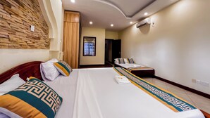 A hotel room with two beds, a stone wall, a wooden wardrobe, and a window. - Kuzuri Kwetu Beachfront Apartments (Mombasa)