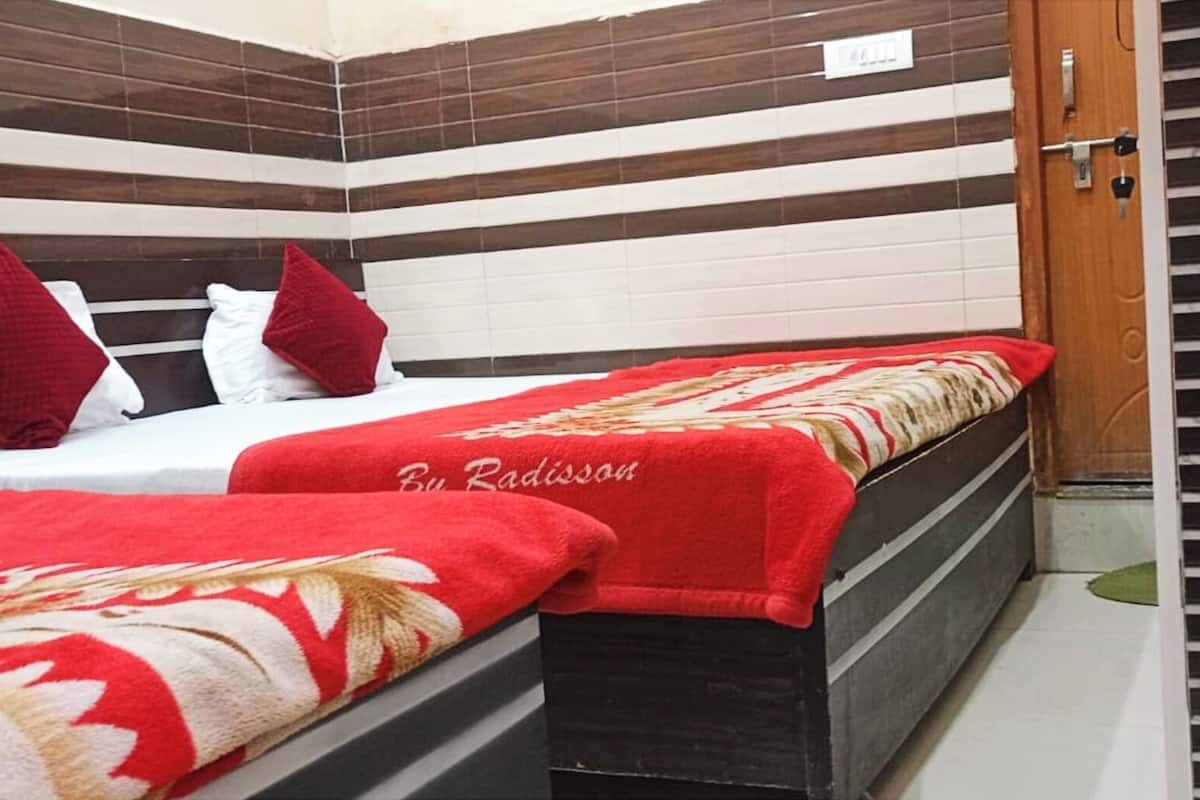 Una habitación de hotel con una cama, un banco y una puerta.