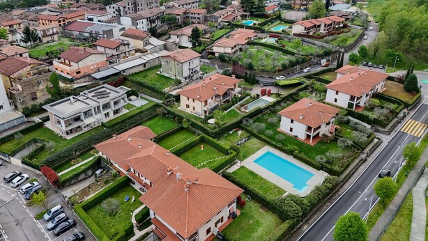 A residential area with houses, a swimming pool, and a road. - Apartment MoKi in Moniga del Garda (Moniga del Garda)