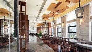 A spacious, modern dining area with wooden flooring, a long table, and several chairs. There are hanging pendant lights and a large window providing natural light. - SSAW Boutique Hotel DeXin - Near Mount Mogan (Huzhou)