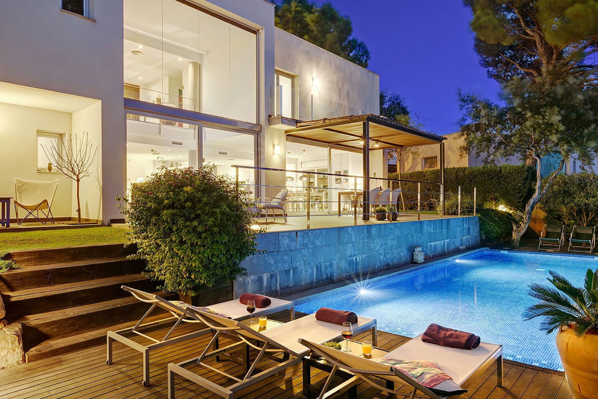 A modern house with a swimming pool, outdoor seating, and a covered patio area.