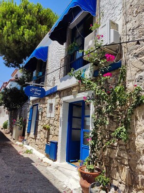 A stone building with blue shutters and a sign for "Gül Hanım Konak."