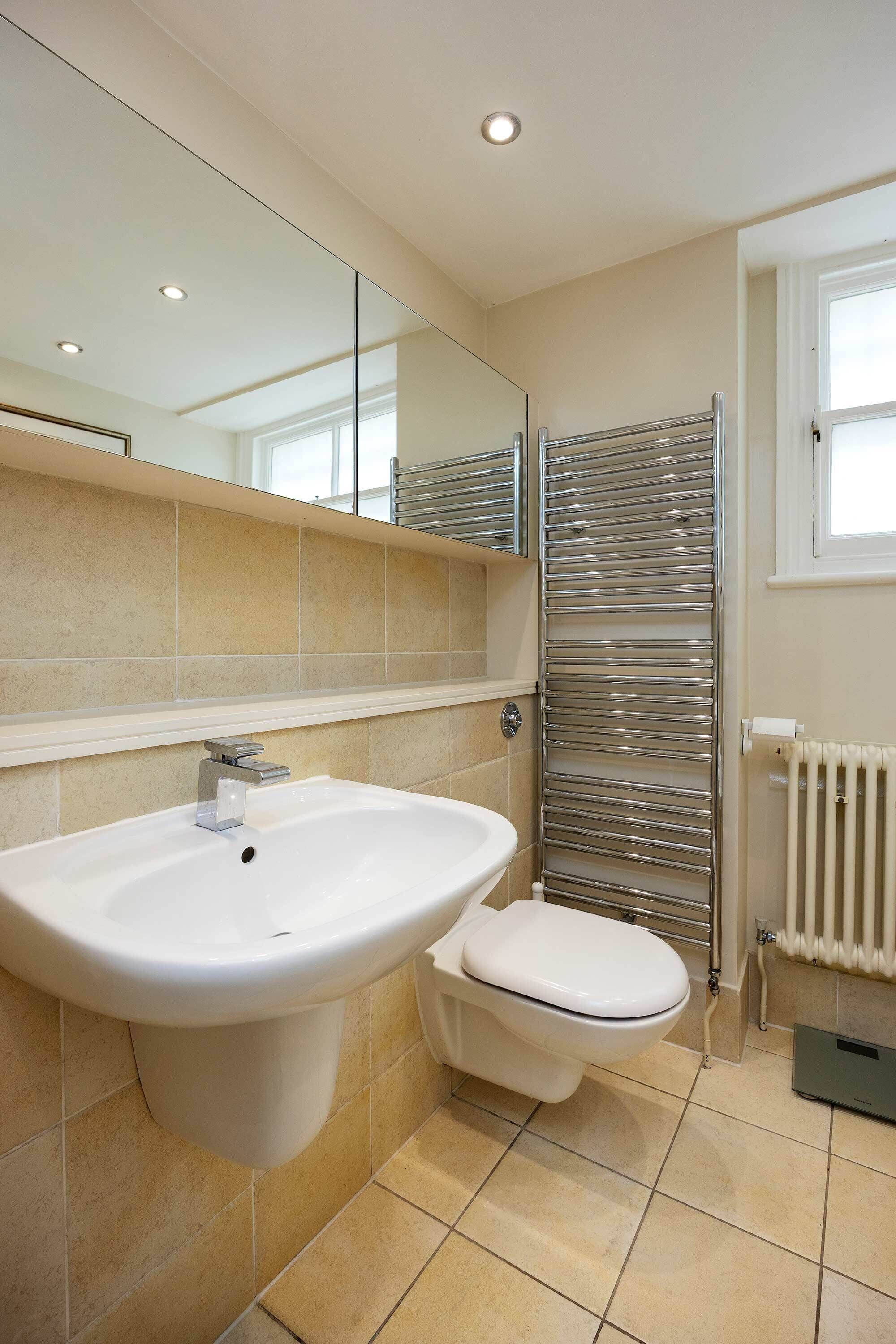 A modern bathroom with a white sink, a toilet, and a glass shower enclosure.