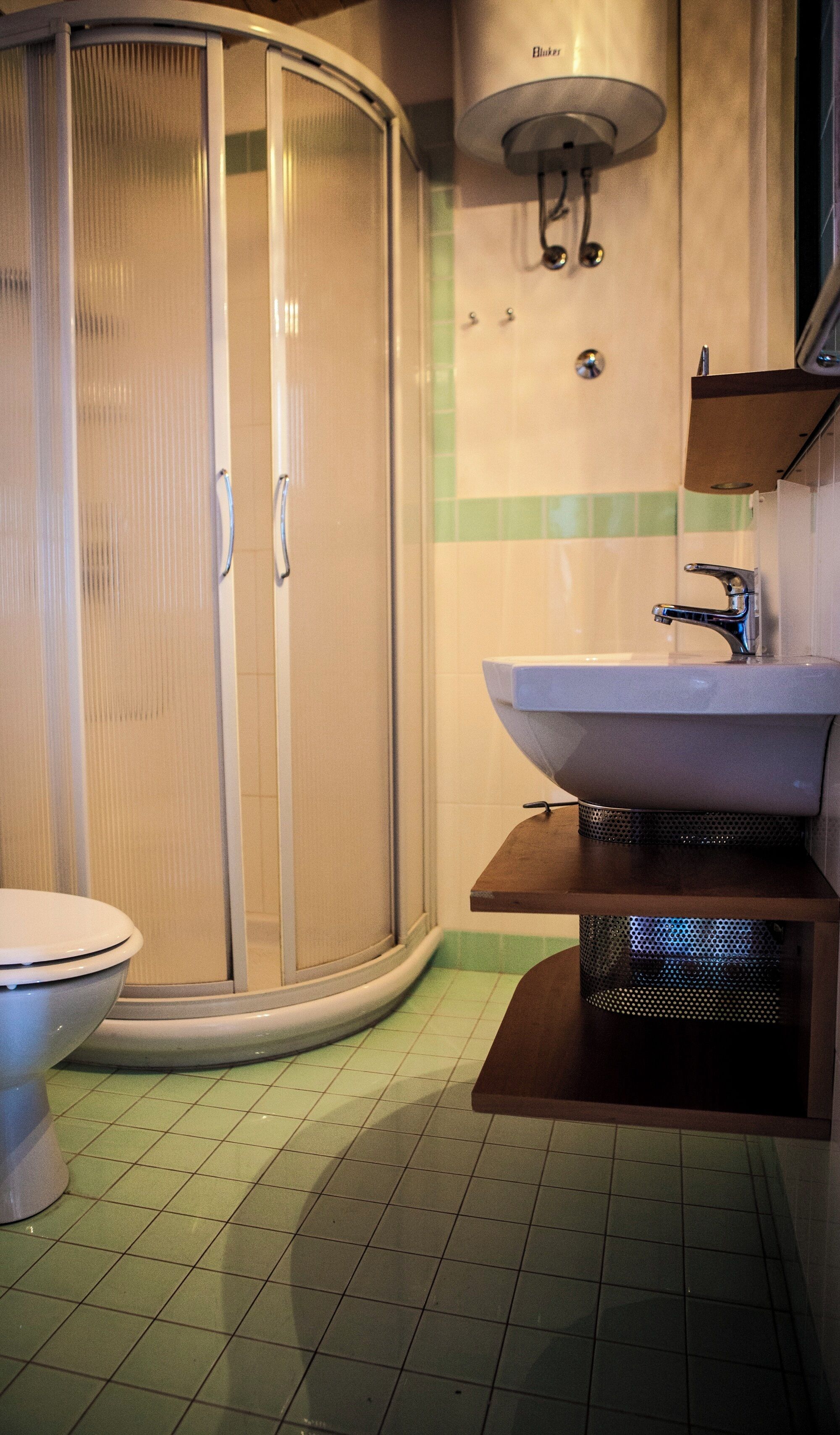 Ein Badezimmer mit Toilette, Duschkabine und Waschbecken mit Spiegel.