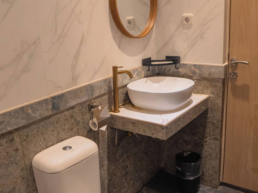 Une salle de bain avec des toilettes, un lavabo et un miroir.