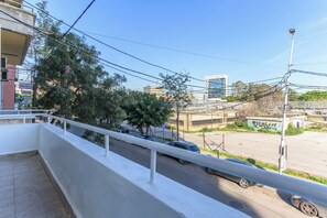 A balcony with a view of a street, trees, and buildings. - Boho Studios & Apts in Mar Mikhael (Beirut)