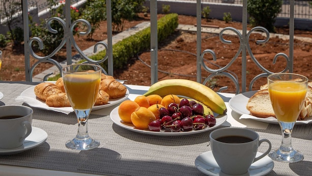 A breakfast table with croissants, fruit, and coffee, overlooking a scenic view of the sea and mountains. - Villa with S. Pool Theologos by GHH (Lokroi)