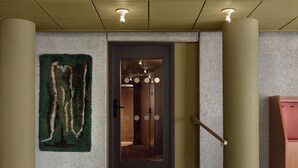 A modern interior with a wooden table, a staircase, and a door leading to a room with circular ceiling lights. - Bob W Stockholm Norrmalm (Stockholm)