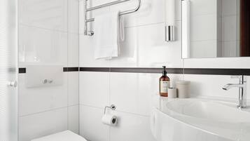 A modern bathroom with a white toilet, a sink, and a towel rack.