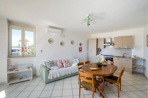 Appartement, balkon, uitzicht op tuin | Woonruimte | Een 32-inch flatscreentelevisie met kabelzenders