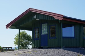A small, green building with a red roof and the number 21 on it.