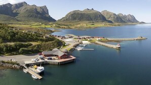 A coastal town with a dock, boats, and a building with a red roof. - Fjordcamp AS (Straumsjøen)