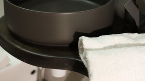 A modern bathroom with a black sink, a white towel, and a white wall. - The Ranch (Goris)