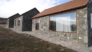 A row of stone buildings with tiled roofs and large windows. - The Ranch (Goris)