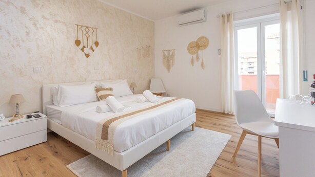 A bedroom with a bed, bedside tables, a desk, and a chair. - Pampas Roma (Rome)