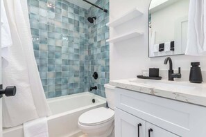 A modern bathroom with a bathtub, toilet, and a vanity with a mirror. - Cheery Lynn II Soft & Stylish Stay (Scottsdale)