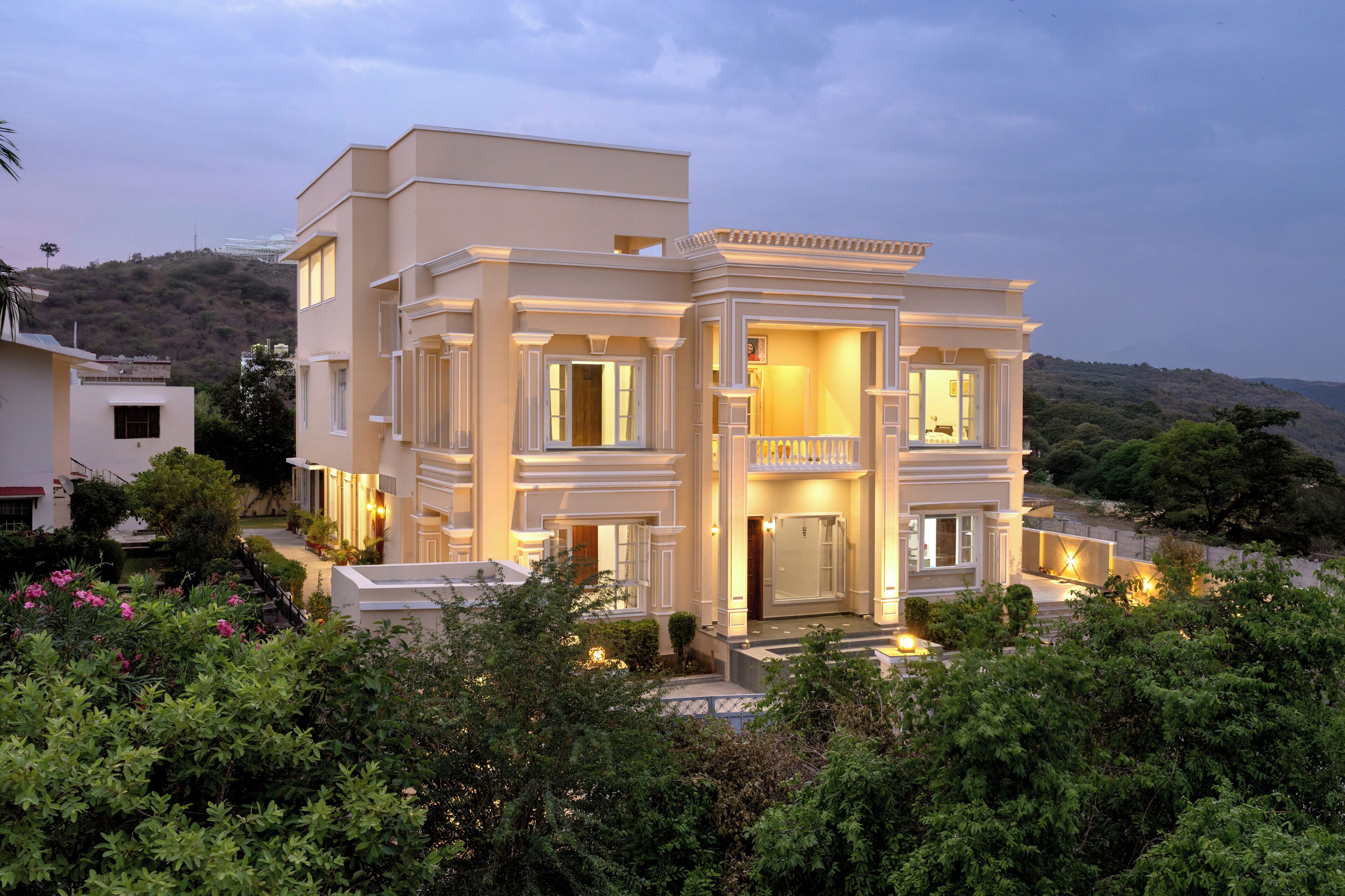 A multi-story building with a balcony and a well-lit entrance.
