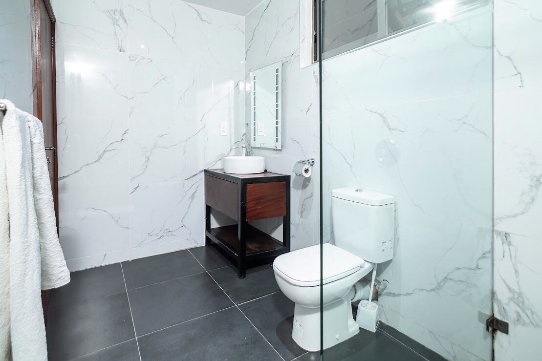 Ein Badezimmer mit Toilette, Waschbecken und Spiegel.