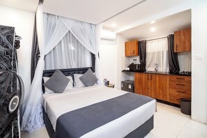 A bedroom with a bed, bedside table, and a nightstand. There is a window with sheer curtains and a black and white patterned wall hanging. - Harry's Kisumu Oasis (Kisumu)