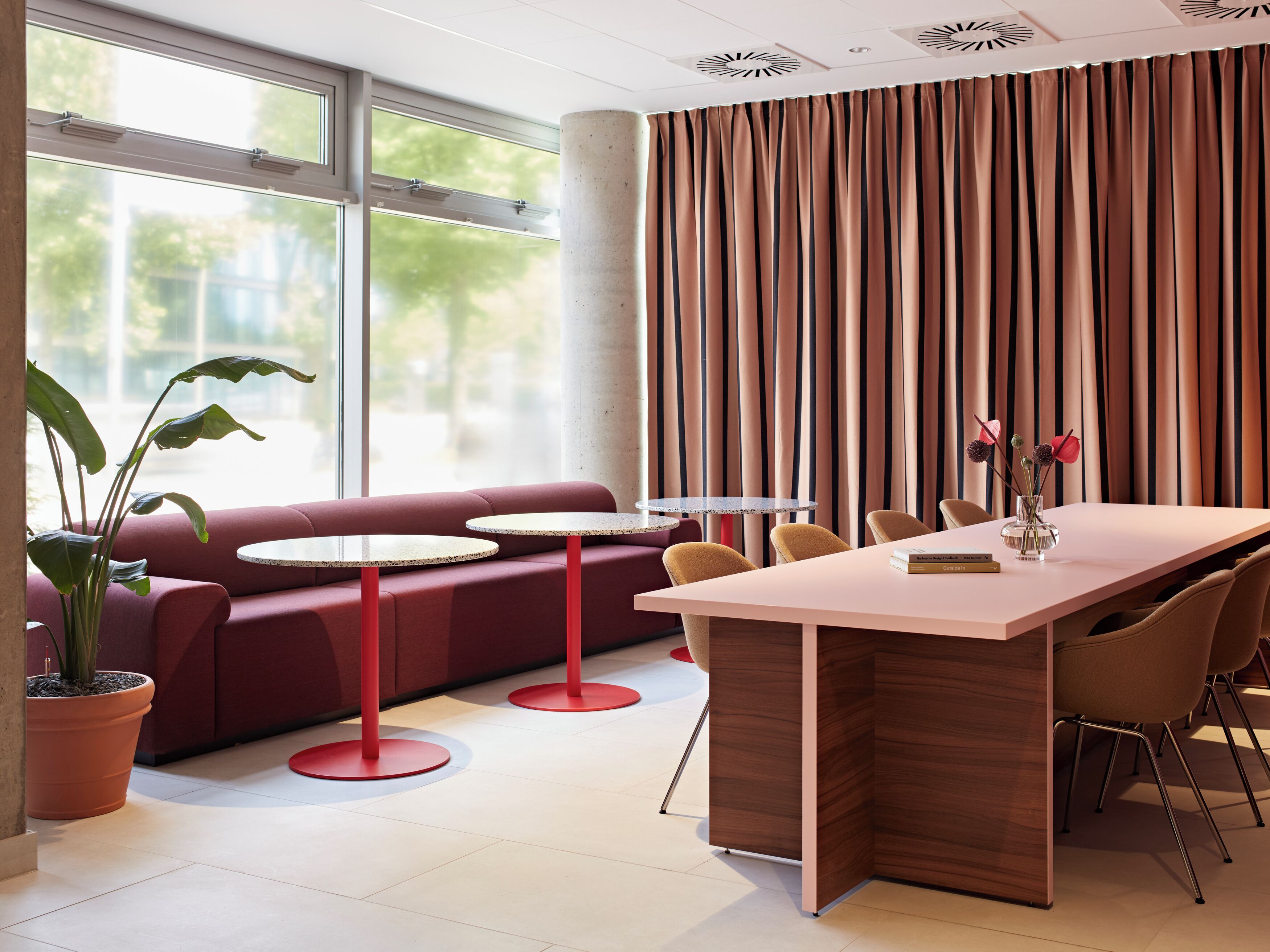 A modern interior with a seating area, a dining table, and a large window.