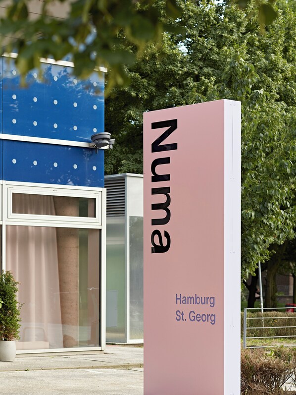 Un cartel con la palabra 'NUNNA' y 'Hamburg St. Georg' que indica una ubicación.
