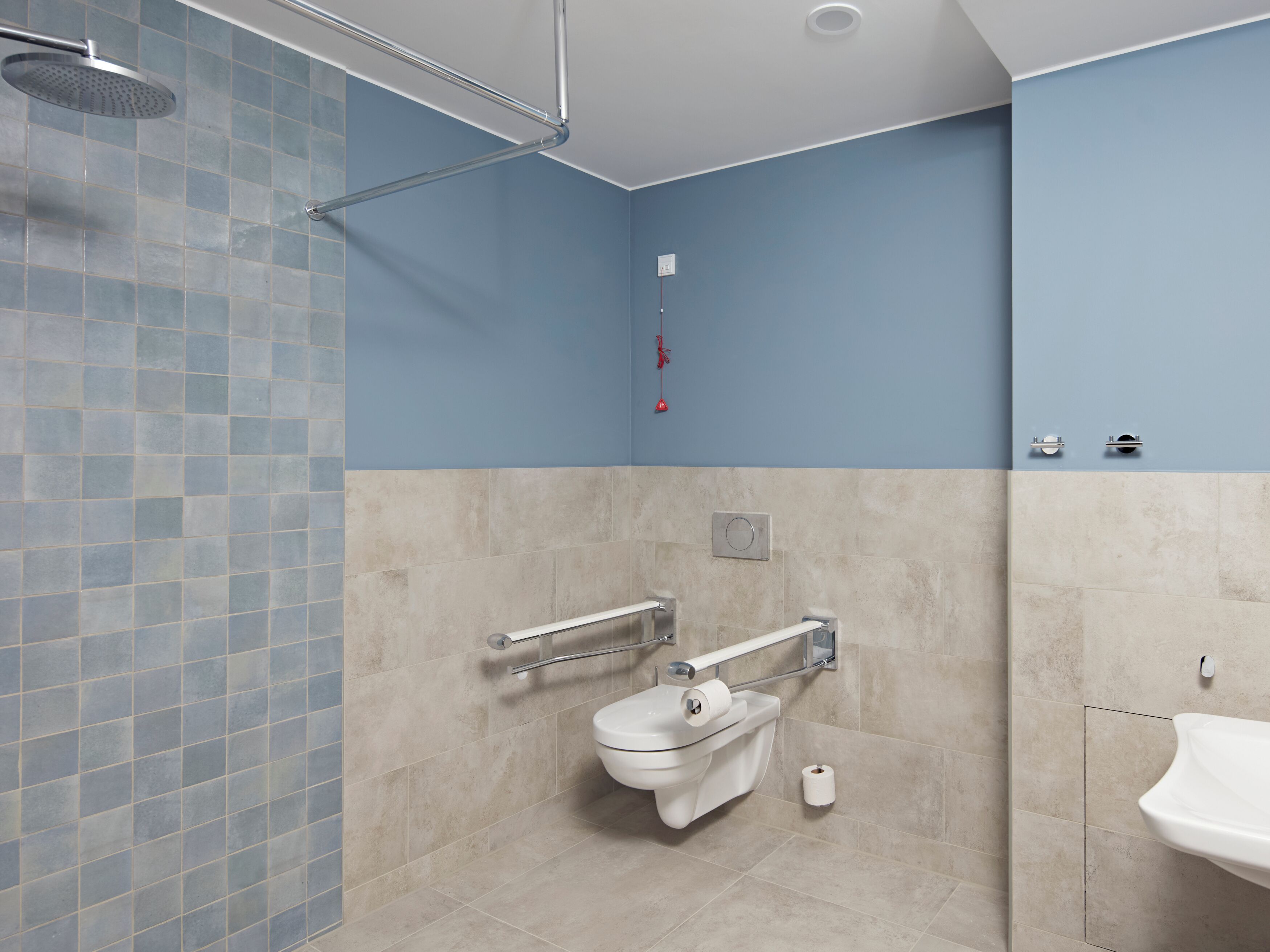 A modern bathroom with a shower, toilet, and sink.