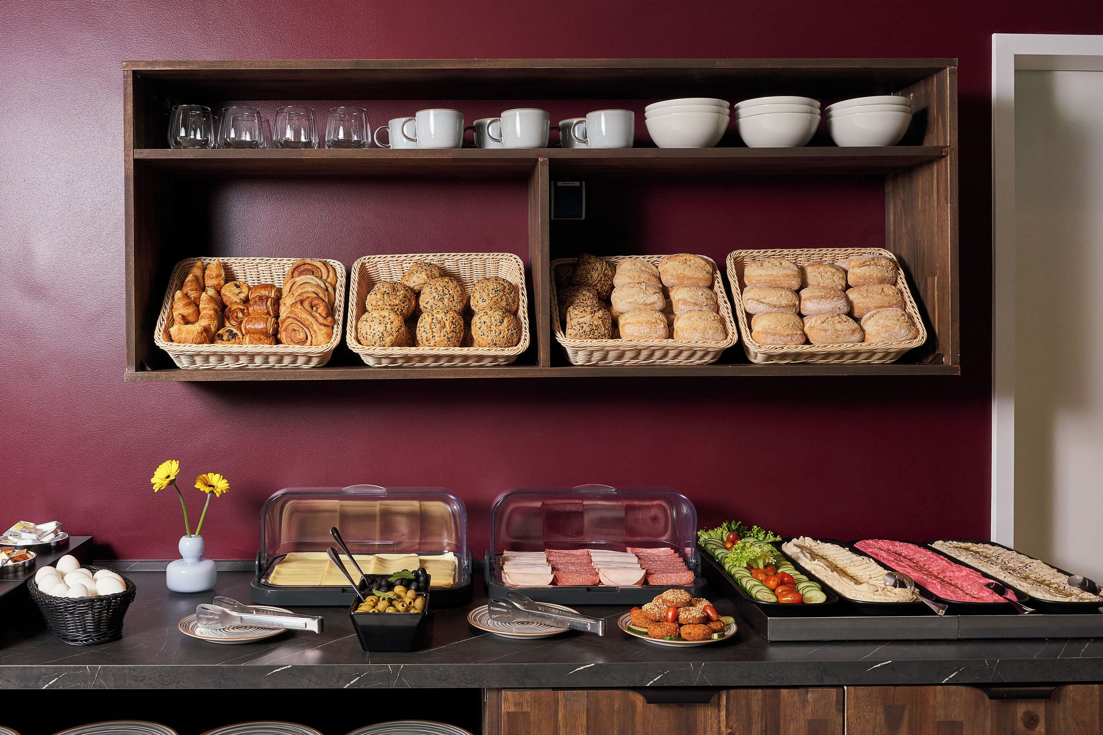 A buffet setup with various food items and serving ware.
