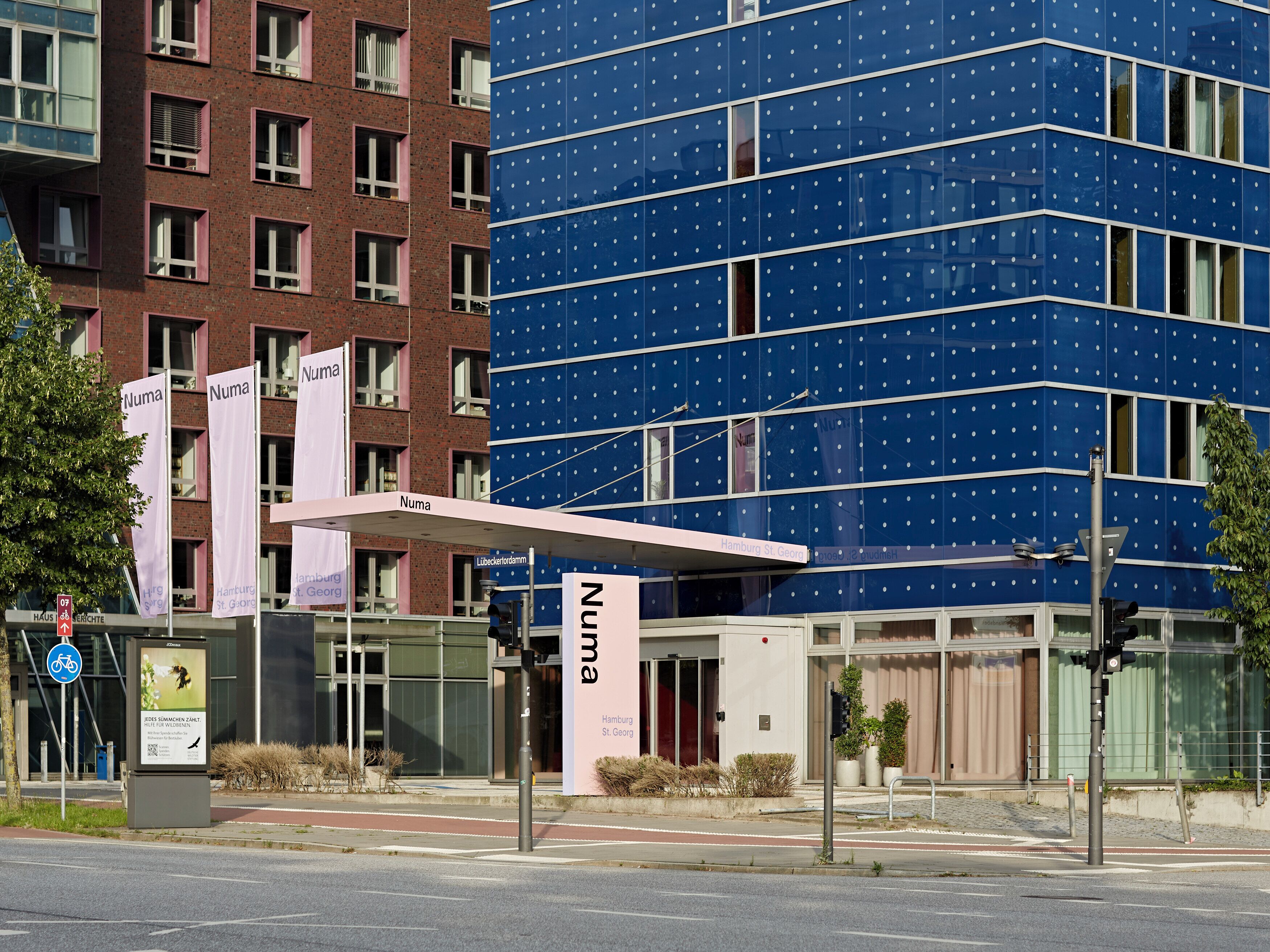 A modern building with a blue facade and multiple windows.
