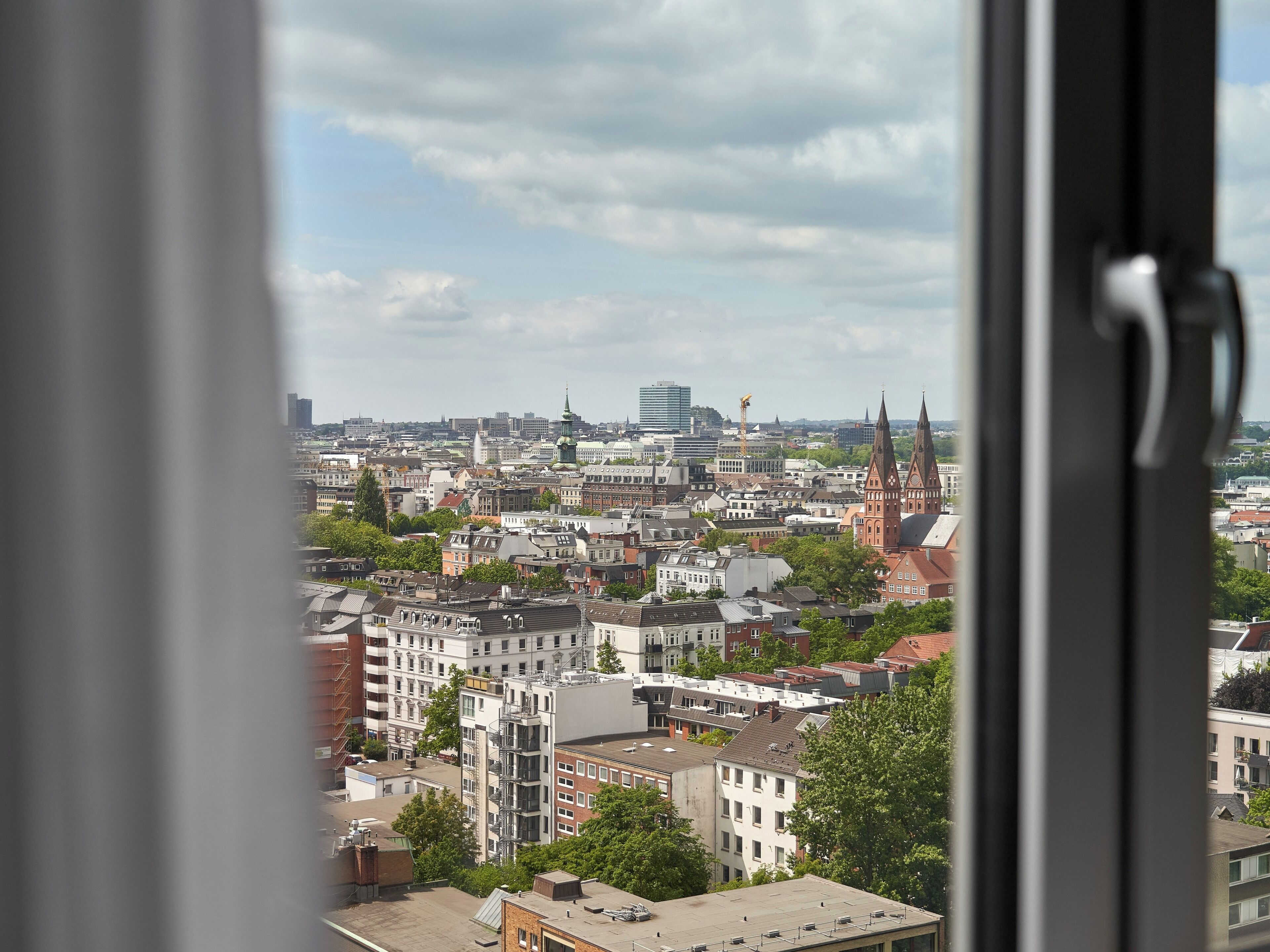 A cityscape with various buildings, including a prominent church with two spires.