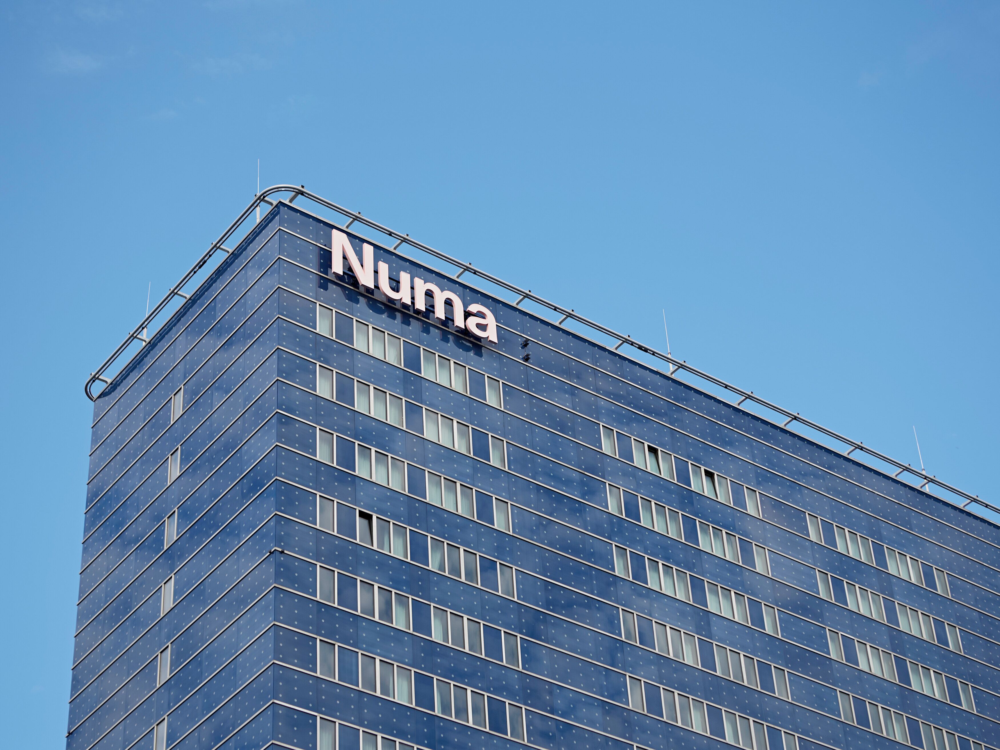 Un bâtiment moderne dont la façade porte en grand le nom « Numa ».