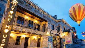 Um edifício histórico com uma placa que diz 'HOTEL HOUSE' e varandas decoradas com luzes de cordão.