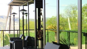 A covered outdoor seating area with chairs and tables, overlooking a scenic landscape. - Panorama Sormoni (Tsqaltubo)