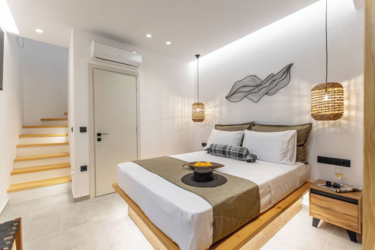 A modern bedroom with a bed, bedside table, and a wall-mounted artwork.