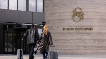 A building entrance with a logo and the text 'BY MITO DEVELOPERS' on the wall.