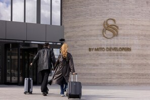 Una entrada de edificio con un logotipo y el texto 'BY MITO DEVELOPERS' en la pared.