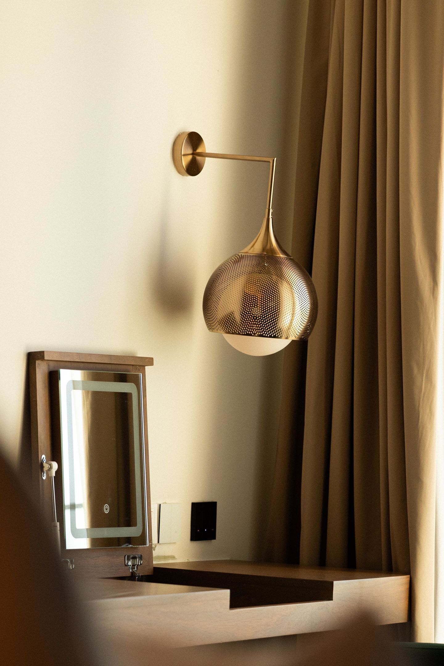 Un baño moderno con espejo, lavamanos e iluminación colgante.