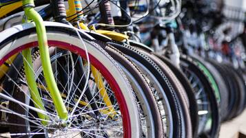 A row of bicycles with various colored tires and handlebars.
