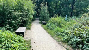 A gravel path flanked by dense greenery and wooden benches. - Hotel Nowa Panorama Double Room with BB and Free WiFi (Kraków)