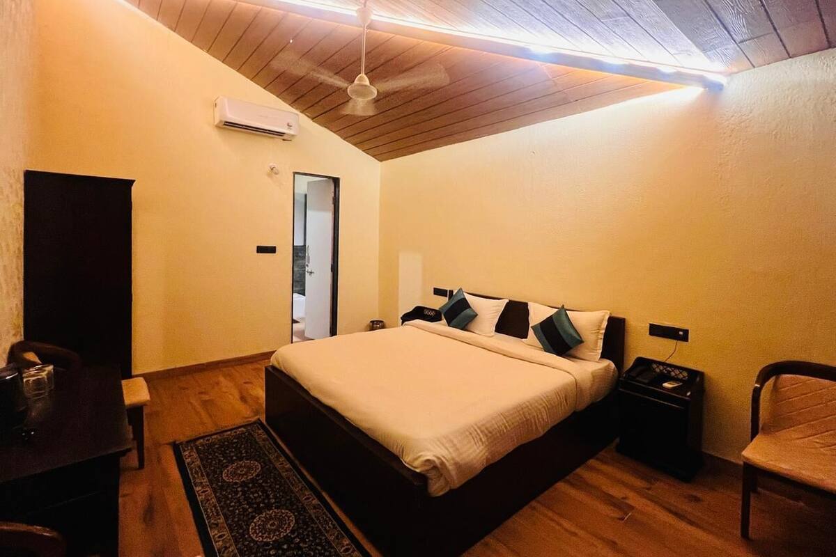 Ein Schlafzimmer mit einem Bett, Nachttischen, einem Schreibtisch und einem Stuhl.