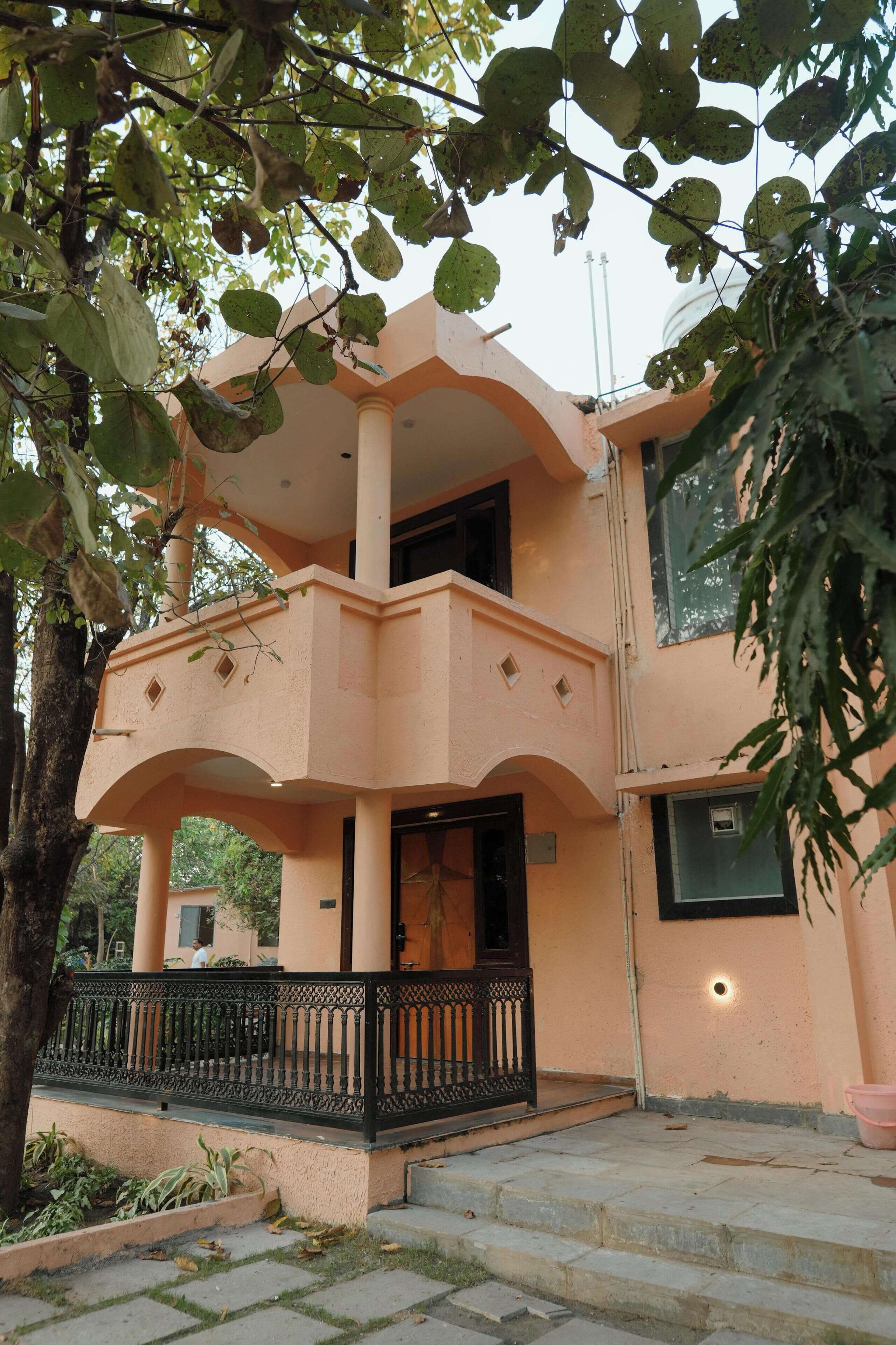 A two-story building with a balcony and a staircase leading to the entrance.
