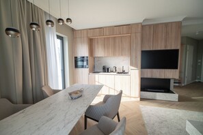 Una cucina moderna con mobili in legno, forno integrato e televisore a schermo piatto.