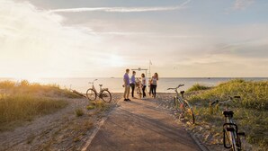 Un sendero pavimentado junto al mar, con bicicletas y gente.