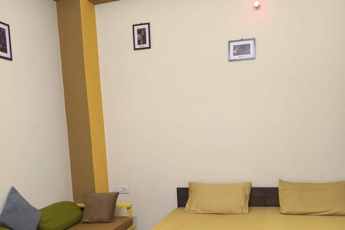 A hotel room with a bed, a sofa, and a small table.