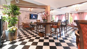 A hotel lobby with a checkered floor, wooden furniture, a television, and a chandelier. - The Sunder Palace- Luxury Boutique Hotel (Jaipur)