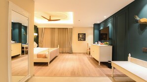 A modern hotel room with a bed, a desk, a vanity, and a ceiling fan. - The Sunder Palace- Luxury Boutique Hotel (Jaipur)