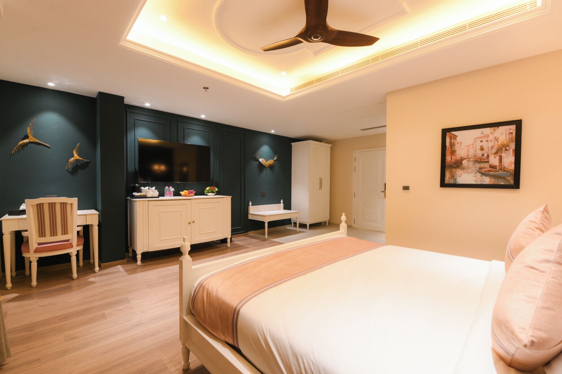 Un dormitorio moderno con cama, escritorio, televisor y armario.