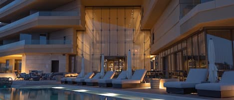 Una piscina cubierta, una piscina al aire libre, sombrillas, tumbonas