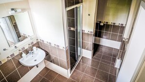 A modern bathroom with a glass shower enclosure, a sink with a mirror, and tiled walls. - Beautiful apartment for 5 guests with WIFI, patio and pets allowed (Ceský Krumlov)