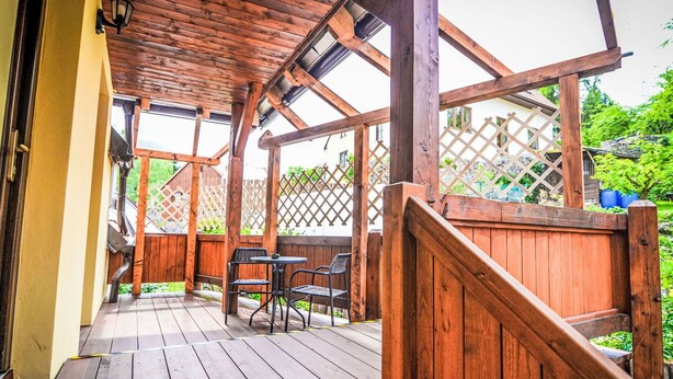 A wooden deck with a pergola, a small table, and two chairs. - Beautiful apartment for 5 guests with WIFI, patio and pets allowed (Ceský Krumlov)