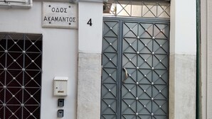 A building entrance with a metal gate, a sign reading "ΔΟΔΣ ΑΚΑΜΑΝΤΟΣ 4", and a utility box. - Ancient Thissio by GHH (Athens)